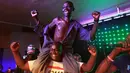 Maison Sere digendong temannya saat merayakan kemenangan usai dinobatkan sebagai pria terjelek pada kontes 'Ugliest Man' di Zimbabwe, 20 November 2015. Sere adalah pria pengangguran yang menang dalam kontes tersebut. (dailymail.co.uk)