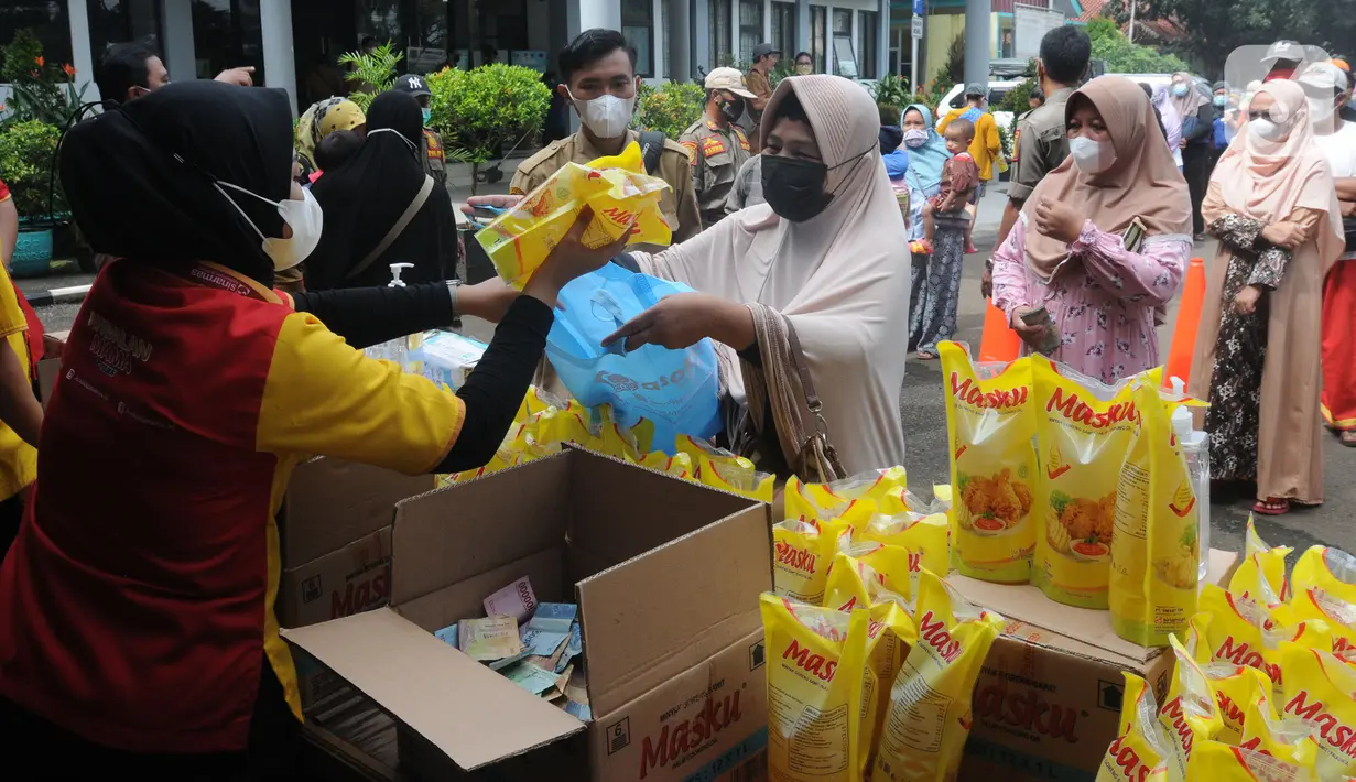 Warga membeli minyak goreng kemasan saat operasi pasar minyak goreng murah di Kantor Kecamatan Pamulang, Tangerang Selatan, Selasa (11/1/20222). Minyak murah itu dijual dengan harga Rp14 ribu per liter dan warga hanya diperbolehkan membeli sebanyak 2 liter. (merdeka.com/Arie Basuki)