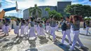 Para siswa melindungi kepala mereka dan diarahkan berlindung dari gedung-gedung yang dapat runtuh serta berlari ke atap Museum Tsunami Aceh. (CHAIDEER MAHYUDDIN/AFP)