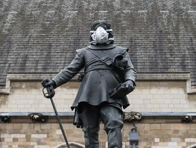 Sebuah masker terpasang pada wajah patung Oliver Cromwell di luar Gedung Parlemen di London, Senin (18/4). Aksi yang dilakukan oleh aktivis lingkungan Greenpeace itu untuk memprotes kualitas polusi udara di kawasan tersebut. (Leon NEAL/AFP)