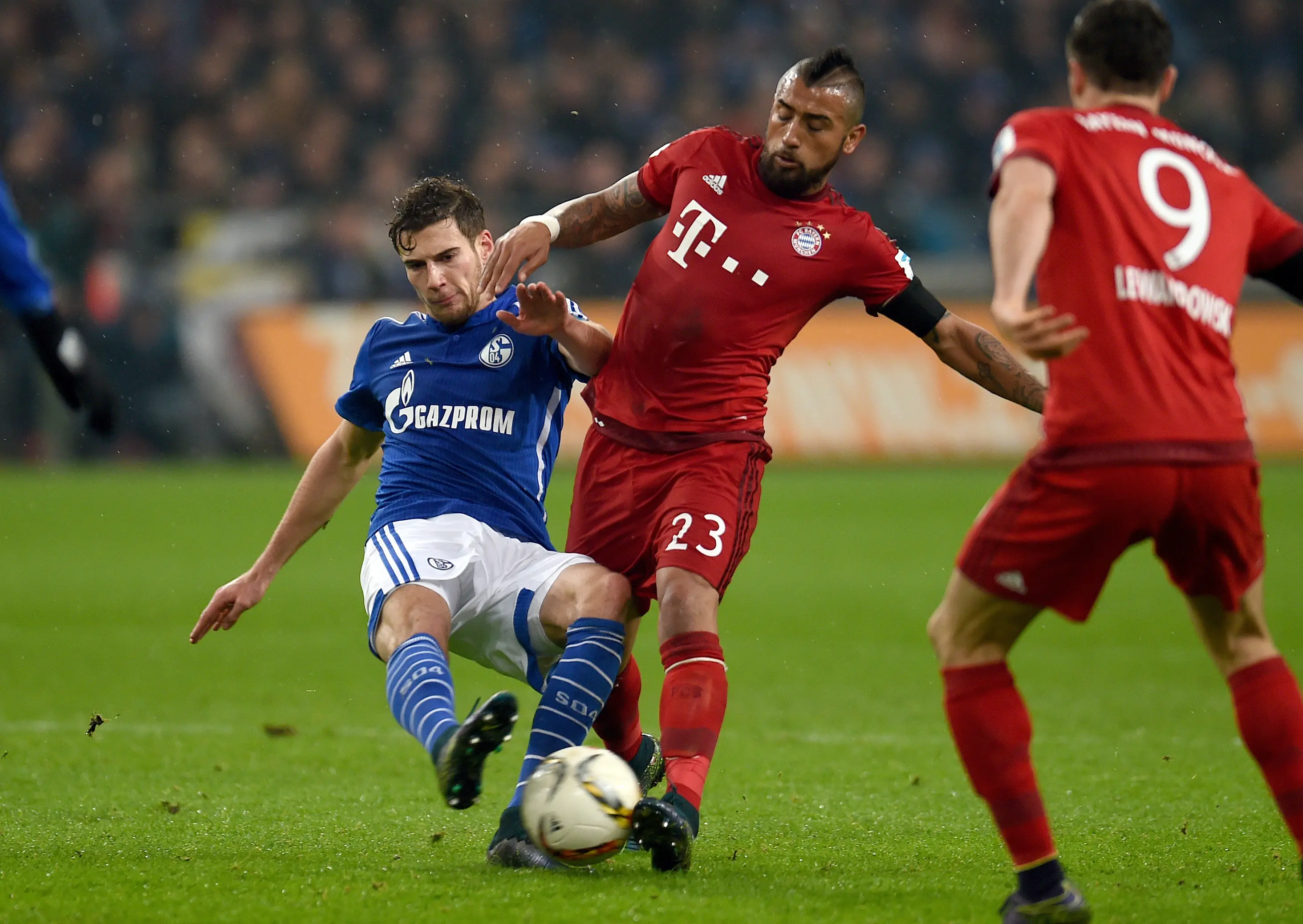 Pemain Bayern Munchen, Arturo Vidal (tengah) berebut bola dengan pemain Schalke 04, Leon Goretzka pada lanjutan Bundesliga di Gelsenkirchen, Jerman, Minggu (22/11/2015) dini hari WIB. (AFP Photo/Patrik Stollarz)