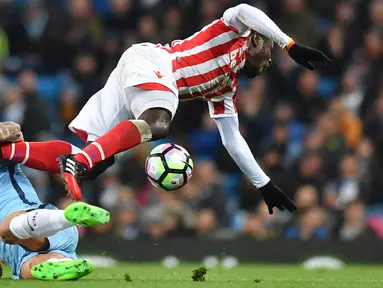 Pemain Manchester City, Aleksandar Kolarov (kiri) menghadang laju pemain Stoke City, Mame Biram Diouf pada lanjutan Premier League di Etihad Stadium, (8/3/2017). Manchester City bermain imbang 0-0.  (AFP/Anthony Devlin)