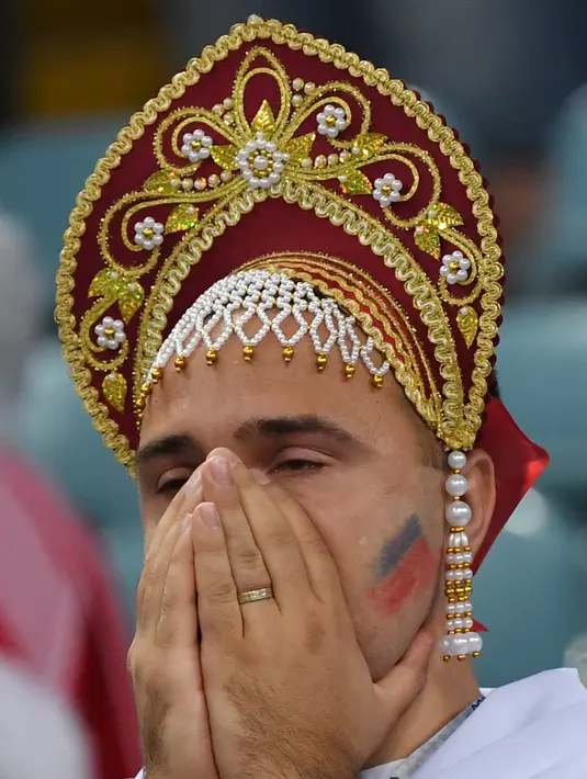 Suporter Rusia menutup wajah lantaran kecewa tim kesayangannya kalah dari Kroasia pada laga perempat final Piala Dunia 2018 di Stadion Olimpiade Fisht, Sabtu (7/7). Tuan rumah Rusia tumbang lewat adu penalti melawan Kroasia 3-4. (Kirill KUDRYAVTSEV/AFP)