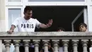 Pemain sepak bola Argentina Lionel Messi (kiri) melambai ke arah fans dari balkon hotel Royal Monceau di Paris pada Selasa (10/8/2021). Di Paris Saint-Germain (PSG), Messi akan dikontrak selama 2 tahun dan menerima gaji €35 juta per musim. (Sameer Al-DOUMY/AFP)