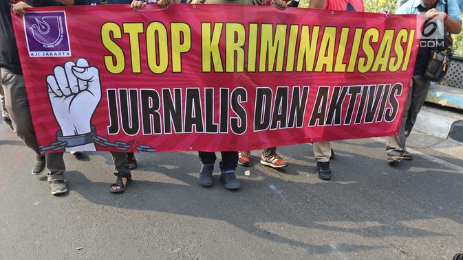 Sejumlah Jurnalis yang tergabung dalam Aliansi Jurnalis Independen (AJI) membentangkan spanduk dan poster saat menggelar aksi menuntut pencabutan status tersangka Dandhy Dwi Laksono pada Car Free Day di Kawasan Bundaran HI, Jakarta, Minggu (29/9/2019).