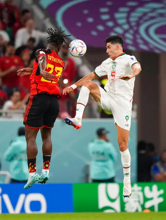 Pemain Belgia Michy Batshuayi (kiri) berebut bola dengan pemain Maroko Nayef Aguerd pada pertandingan sepak bola Grup F Piala Dunia 2022 di Stadion Al Thumama, Doha, Qatar, 27 November 2022. Maroko mengalahkan Belgia dengan skor 2-0. (AP Photo/Frank Augstein)