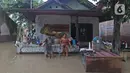 Keluarga Pak Ranin berpose di depan kediamannya Desa Sumber Urip Pebayuran, Kabupaten Bekasi, Jawa Barat, Senin (22/2/2021). Banjir merenda keluarga tersebut merapikan barang-barang dan bersihkan rumah yang sudah surut. (Liputan6.com/Herman Zakharia)