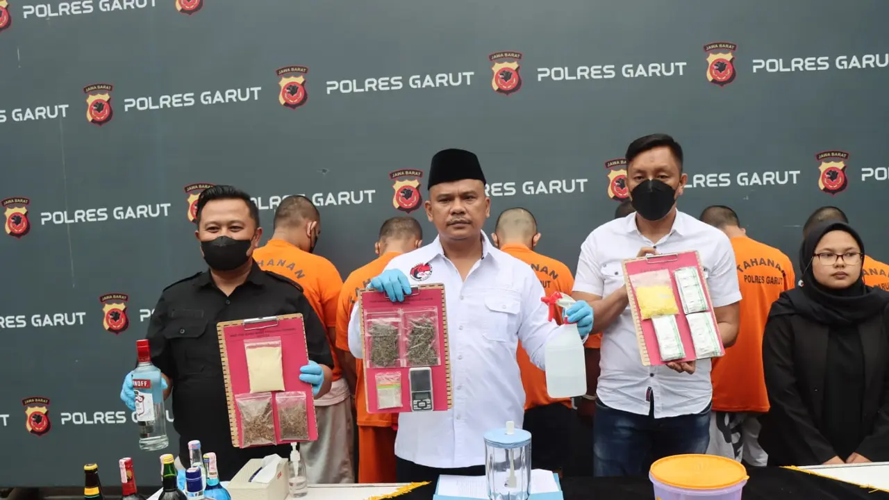 Kasat Narkoba Polres Garut, AKP Jimmy Sihite, didamping petugas menunjukan barang bukti tembakau sintetis dalam rilis kasus di Mapolres Garut, Kamis (20/10/2022) petang. (Liputan6.com/Jayadi Supriadin)