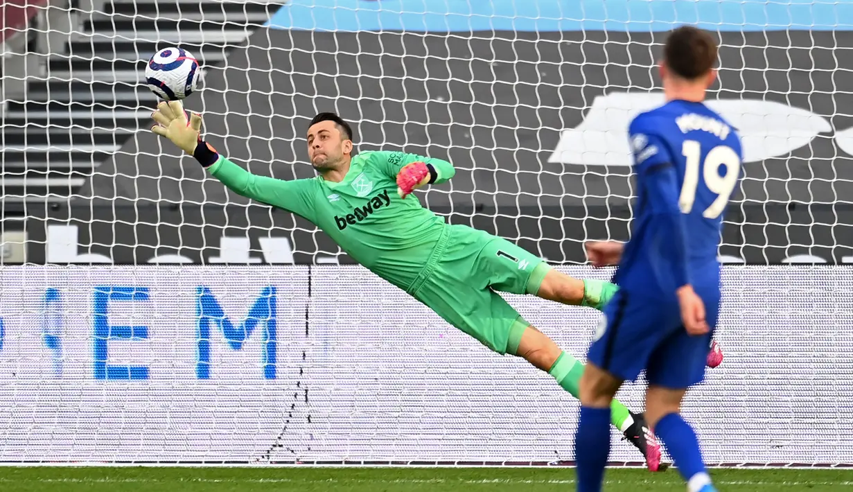 Kiper West Ham United, Lukasz Fabianski melakukan penyelamatan saat melawan Chelsea dalam laga lanjutan Liga Inggris 2020/2021 pekan ke-33 di The London Stadium, London, Sabtu (24/4/2021). West Ham kalah 0-1 dari Chelsea. (AFP/Andy Rain/Pool)