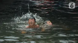 Anak-anak bermain di kawasan Muara Angke, Jakarta, Sabtu (10/4/2021). Minimnya lapangan dan taman-taman hingga kondisi laut yang terlalu kotor merupakan bentuk tak terpenuhinya hak-hak dasar anak-anak nelayan di Jakarta. (merdeka.com/Imam Buhori)