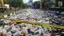 Alat berat menggilas ribuan botol minuman keras  (miras) hasil sitaan polisi di halaman Polres Bogor, Cibinong, Kamis (17/5). Miras yang dimusnahkan lebih dari 32 ribu botol, baik lokal maupun impor dengan beragam merek. (Merdeka.com/Arie Basuki)