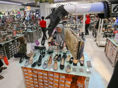 Pengunjung memilh sepatu untuk merayakan Hari Raya Idul Fitri di Lippo Mall Puri, Jakarta, Jumat (24/5/2019). Untuk menarik pengunjung dalam rangka Festival Jakarta Great Sale, berbagai diskon ditawarkan dari pukul 20.00 hingga 00.00 dalam Midsummer Night Sale. (Liputan6.com/Fery Pradolo)