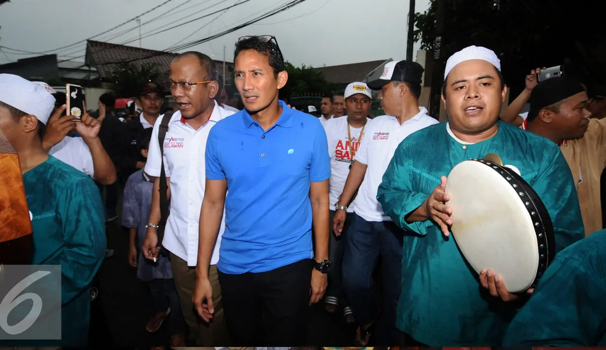 Cawagub DKI Jakarta, Sandiaga S Uno (tengah) bersiap menemui pendukungnya di Jalan Tanjung Barat Selatan, Jakarta, Minggu (20/11). Sandiaga melantik relawan komunitas Anies-Sandi tingkat RW Kelurahan Lenteng Agung. (Liputan6.com/Helmi Fithriansyah)