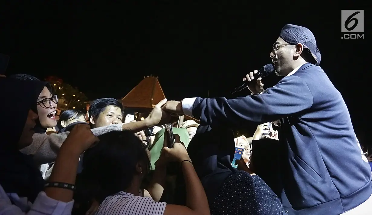 Rio Febrian memegang tangan penonton saat tampil dalam acara Balkonjazz Festival 2019, di Balkondes Tuksono, Borobudur, Magelang, Jawa Tengah, Sabtu (14/9/2019). Rio sukses bikin baper dan menghipnotis ribuan penonton dengan melantunkan sekitar 10 lagu hitsnya. (Fimela.com/Bambang Ekaros Purnama)