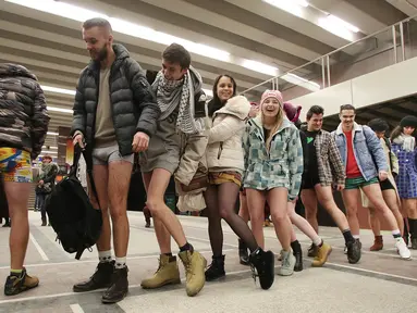 Penumpang mengantre naik kereta tanpa mengenakan celana selama berpartisipasi dalam 'No Pants Subway Ride' di Polandia (8/1). Acara tahunan ini digelar di berbagai negara khususnya naik kereta tanpa memakai celana. (AP Photo/Czarek Sokolowski)