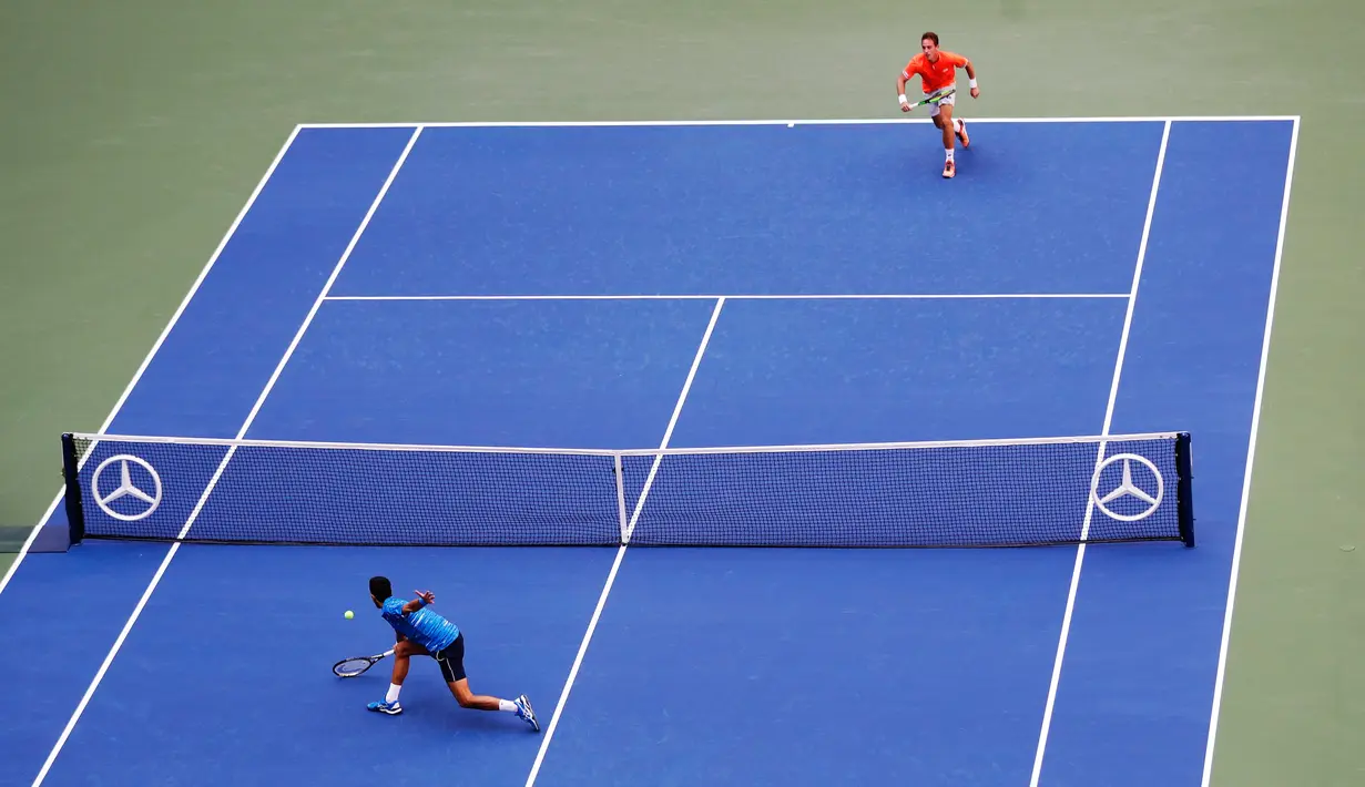 Petenis Serbia, Novak Djokovic (kiri) mengembalikan bola ke arah Roberto Carballes Baena dari Spanyol pada  babak pertama AS Terbuka 2019 di Billie Jean King National Tennis Center, New York, Senin (26/8/2019). Unggulan pertama itu memetik kemenangan 6-4, 6-1, 6-4. (AP/Frank Franklin II)