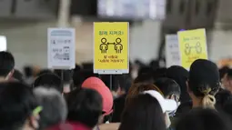 Tanda-tanda jarak sosial terlihat saat penumpang menunggu untuk naik pesawat menjelang liburan Chuseok mendatang, Hari Thanksgiving versi Korea di terminal penerbangan domestik bandara Gimpo di Seoul, Korea Selatan (18/9/2021). (AP Photo/Ahn Young-joon)