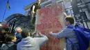 Para pengunjuk rasa mendirikan sebuah plakat saat berunjuk rasa di depan gedung Kedutaan Besar Rusia di Kiev, Ukraina, (14/6/2014). (REUTERS/Oleg Pereverzev)