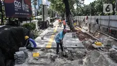 Pekerja menyelesaikan proyek revitalisasi trotoar di Jalan Medan Merdeka Selatan, Jakarta Pusat, Selasa (22/11/2022). Pemprov DKI Jakarta mengalokasikan anggaran sebesar Rp 171 miliar dalam Rancangan Anggaran Pendapatan dan Belanja Daerah (RAPBD) DKI Jakarta 2023 untuk revitalisasi trotoar di Ibu Kota. (merdeka.com/Iqbal S. Nugroho)