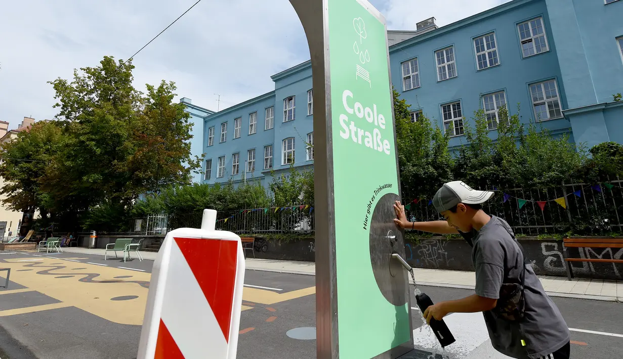 Seorang anak mengambil air minum di "jalan sejuk" yang disediakan di Waltergasse, Wina, 20 Juli 2020. Wina menyediakan 22 "jalan sejuk" untuk yang ingin menyejukkan diri, lengkap dengan berbagai fasilitas seperti mainan, alat olahraga dan air bersih gratis hingga 20 September 2020. (Xinhua/Guo Chen)