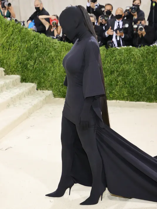 Kim Kardashian menghadiri gelaran Met Gala 2021 di Metropolitan Museum of Art, New York City, Senin (13/9/2021). Kim Kardashian melengkapi penampilan misteriusnya dengan sepatu hak tinggi yang juga berwarna hitam. (Mike Coppola/Getty Images via AFP)