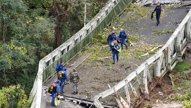 Jembatan Gantung Ambruk: Tim penyelamat berjalan di atas jembatan gantung yang ambruk di atas sungai Tarm, Prancis, (18/11/2019). Jembatan yang menghubungkan kota Mirepoix-sur-Tarn itu tiba-tiba ambruk hingga menyebabkan seorang gadis berusia 15 tahun dan satu sopir truk tewas. (ERIC CABANIS/AFP)