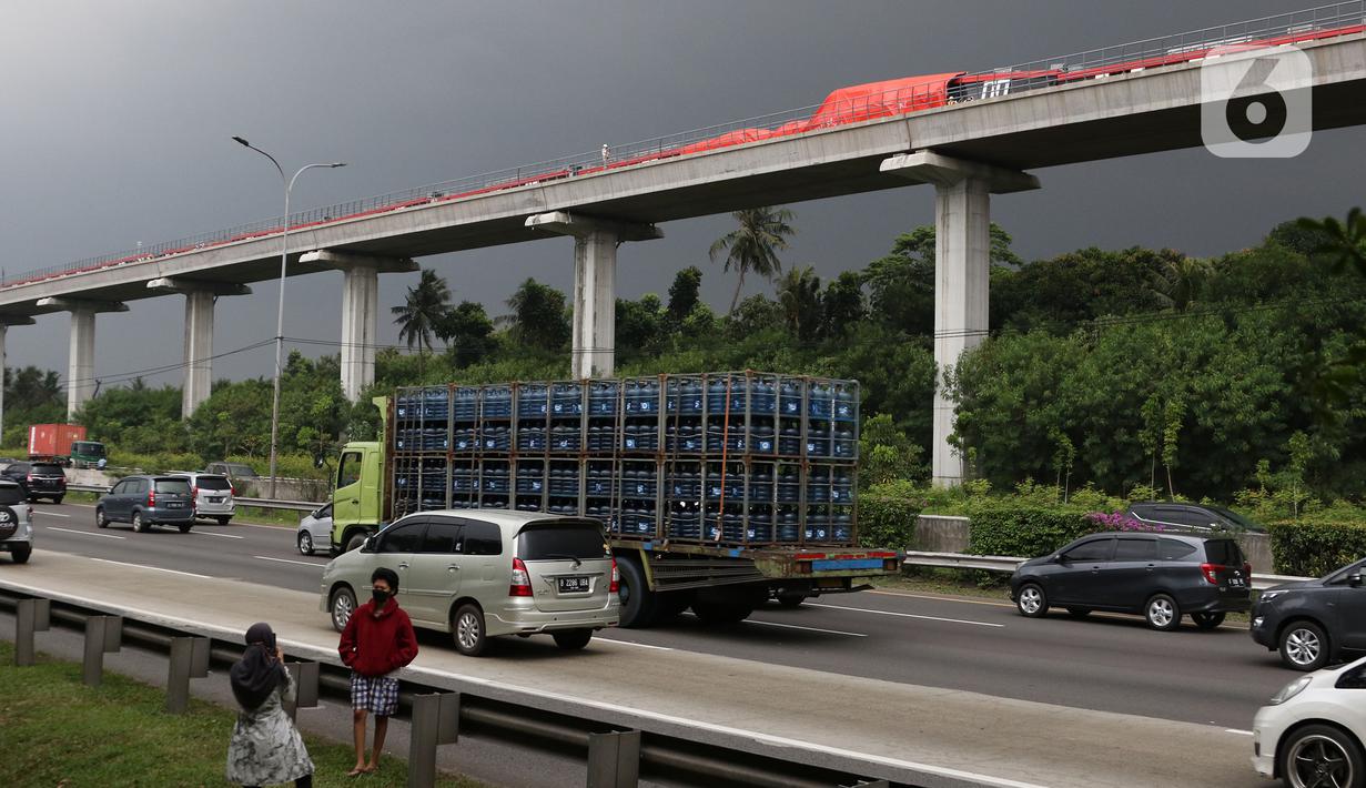 Kendaraan melintas di bawah kereta ringan lintas rel terpadu (LRT) Jabodebek yang mengalami kecelakaan di jalur lintas LRT Cibubur, Jakarta Timur, Senin (25/10/2021). Dua kereta LRT tersebut sedang uji coba saat tabrakan terjadi sehingga gerbong kosong. (Liputan6.com/Herman Zakharia)