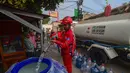 Petugas Palang Merah Indonesia (PMI) mengisi air bersih ke dalam toren air milik warga di RW 08. Cipayung Jaya, Kota Depok, Jawa Barat, Jumat (14/07/2026).