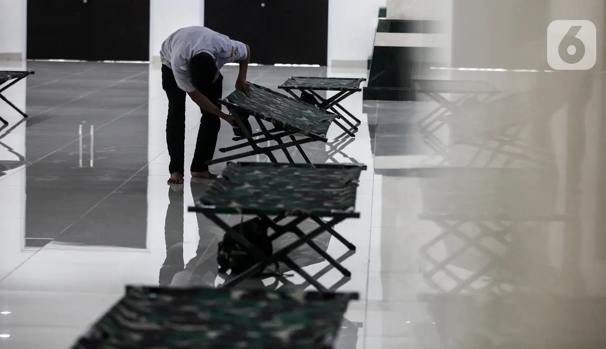 Petugas menyiapkan tempat isolasi di Aula Masjid KH Hasyim Asyari atau Masjid Raya Jakarta, Daan Mogot, Jumat (25/6/2021). Pemprov DKI menetapkan sejumlah lokasi menjadi tempat isolasi mandiri warga yang positif COVID-19, salah satunya adalah Masjid KH Hasyim Asyari. (Liputan6.com/Johan Tallo)