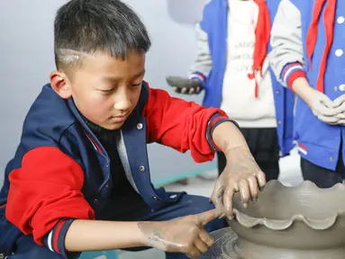 Sejumlah siswa sekolah dasar mencoba membuat porselen di bengkel kerja porselen Ru di Baofeng, Provinsi Henan, China, 15 November 2020. Baofeng dikenal sebagai produsen porselen Ru, satu dari lima porselen yang tersohor selama era Dinasti Song (960-1279) pada zaman China kuno. (Xinhua/He Wuchang)
