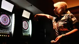 Mikuru Suzuki melempar anak panah saat bermain darts di Tokyo, Jepang, 8 April 2019. Nama Mikuru Suzuki mulai mencuri perhatian setelah memenangkan kejuaraan dunia darts BDO pada Januari lalu. (CHARLY TRIBALLEAU/AFP)