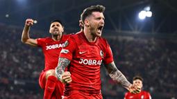 Namun, mereka mampu mengembalikan kedudukan menjadi 3-1 atau agregat 4-3 melalui gol Lukas Kubler (19', 72') dan Johan Manzambi (41') serta sukses memanfaatkan keunggulan pemain setelah tim tamu kehilangan satu pemain akibat kartu merah pada menit keenam. (AP Photo/DPA/Philipp von Ditfurth)