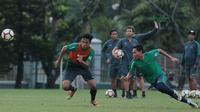 Evan Dimas (kanan) berebut bola dengan Hanif Sjahbandi saat berlatih di Lapangan ABC, Senayan,  (24/4/2018). Timnas akan mengikuti turnamen PSSI Anniversary 27 April-3 Mei 2018. (Bola.com/Nicklas Hanoatubun)