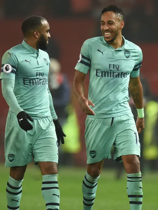 Striker Arsenal, Pierre-Emerick Aubameyang berbincang Alexandre Lacazette usai pertandingan melawan Manchester United pada pertandingan lanjutan Liga Inggris di stadion Old Trafford (5/12). MU bermain imbang 2-2 atas Arsenal. (AFP Photo/Oli Scarff)