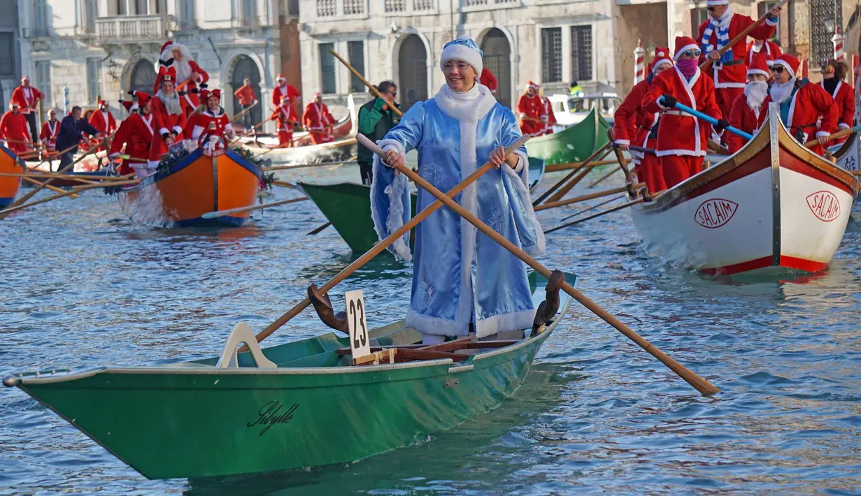 Ratusan orang mengenakan kostum Santa Claus mendayung perahu di Canal Grande di Venesia, Italia, (17/12). Hampir seratus perahu dayung tradisional, dengan berbagai jenis dan ukuran berparade di sepanjang Grand Canal. (Andrea Merola / ANSA via AP)
