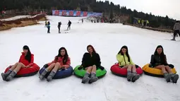 Lima wanita bermain snow tubing tanpa mengenakan celana saat ikut berpatisipasi dalam No Pants Subway Ride di Dugongshan Ski Resort, Cina. Foto diambil Selasa (13/01/2015). (CHINA OUT AFP PHOTO)