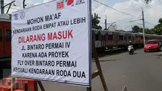 Sebuah papan pengumuman terpasang di dekat perlintasan kereta api Bintaro, Jakarta, Minggu (19/3). Rencana penutupan perlintasan rel kereta Bintaro ini per 1 April arus lalu lintas akan di alihkan ke jalan alternatif lainnya. (Liputan6.com/Helmi Afandi)