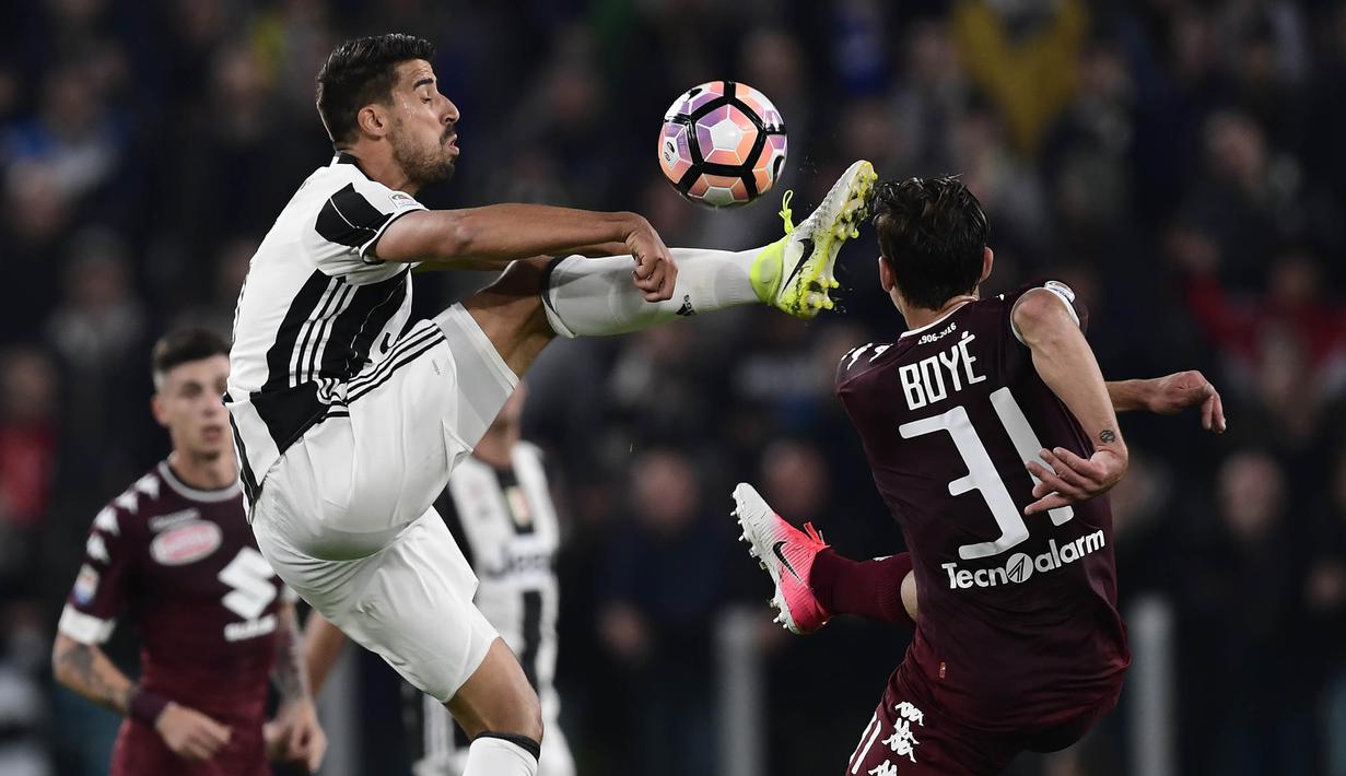 Gelandang Juventus, Sami Khedira, berebut bola dengan gelandang Torino, Lucas Boye. Juventus mendominasi pertandingan dengan 58 persen penguasaan bola berbanding 42 persen milik Torino. (AFP/Miguel Medina)