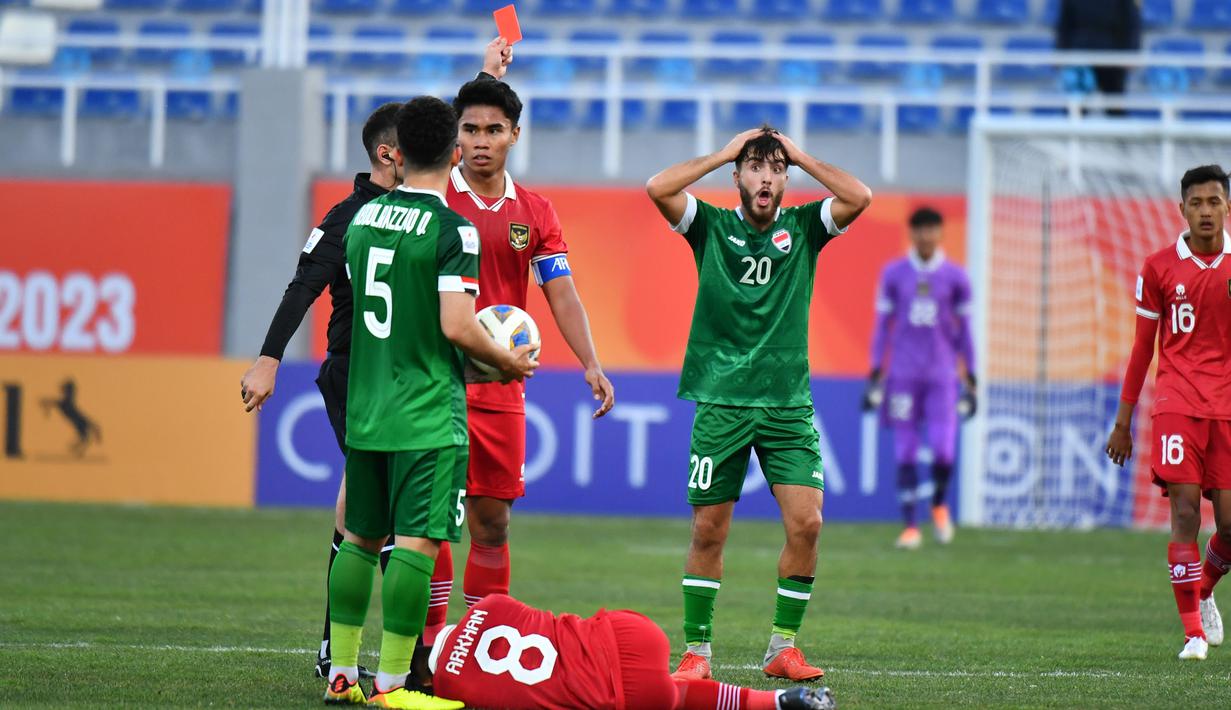 <p>Wasit memberikan kartu merah kepada pemain Irak U-20, Charbel Awni Shamoon (tengah) setelah melakukan pelanggaran keras terhadap pemain Timnas Indonesia U-20, Arkhan Fikri pada laga matchday pertama Grup A Piala Asia U-20 2023 di Lokomotiv Stadium, Tashkent, Uzbekistan, Rabu (1/3/2023). (the-afc.com)</p>