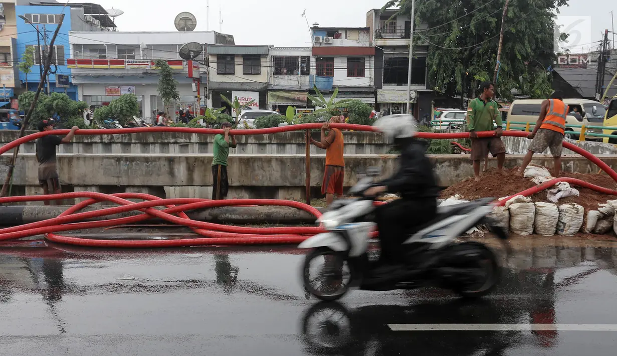 Pekerja memasukkan kabel jaringan utilitas ke dalam tanah di kawasan Kemayoran, Jakarta, Minggu (14/1). PT PLN Disjaya melakukan ini untuk mendukung Pemprov DKI Jakarta mewujudkan smart city. (Liputan6.com/Immanuel Antonius)