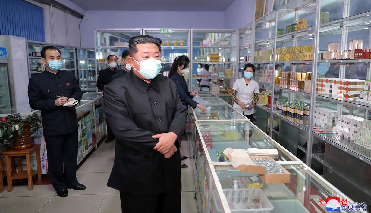 Pemimpin Korea Utara Kim Jong Un mengenakan masker memeriksa apotek di tengah wabah Covid-19 di Pyongyang, Korea Utara pada 15 Mei 2022. Sejak negara itu pertama terkena wabah COVID-19, Apotek Korea Utara sekarang buka 24 jam sehari. (STR/KCNA VIA KNS/AFP)