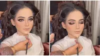 Wajah cantik Putri Isnari di hari bahagianya ini dipoles oleh MUA Adela Angra. Ini adalah potret Putri ketika proses makeup. Meski belum sempurna, namun aura Putri Isnari sudah terpancar bahkan wajahnya sangat berbeda. Tampil memukau di hari pernikahannya, tak sedikit netizen yang memuji penampilan dan tema resepsi pernikahan penyanyi kelahiran 2004 ini. (Liputan6.com/IG/@adelahaddad17)