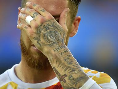 Pemain Spanyol, Sergio Ramos memiliki tato mawar dan nama ayahnya (Paqui) serta salib ditangan kirinya saat berlaga pada grup D Euro Cup 2016 melawan Kroasia di Stadion Matmut Atlantique, Bordeaux, (22/6/2016). (AFP/Loic Venance)