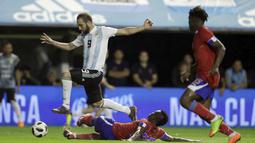 Gaya pemain Argentina, Gonzalo Higuain melompat menghidari adangan pemain Haiti pada laga uji coba di Buenos Aires, Argentina, (29/5/2018). Argentina menang 4-0. (AP/Victor R. Caivano)