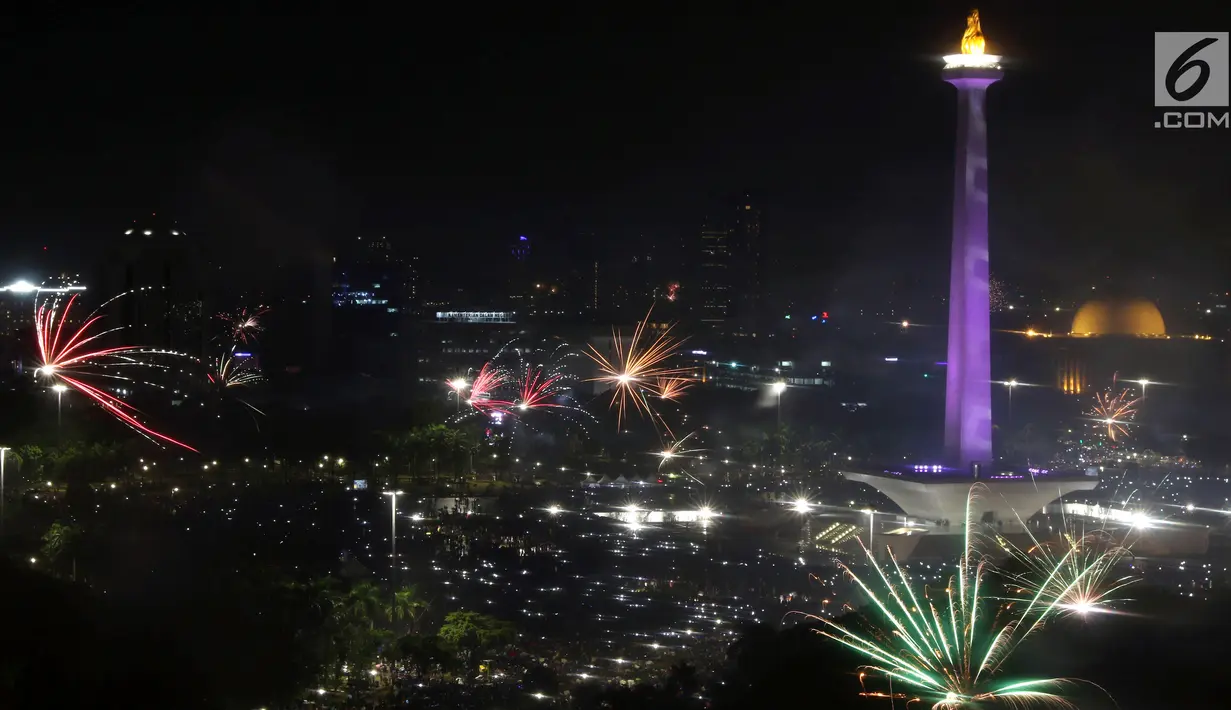 Kembang api menyala menyambut pergantian tahun 2018 ke 2019 di kawasan Monumen Nasional, Jakarta, Selasa (1/1). Ribuan orang merayakan malam pergantian tahun di halaman Monumen Nasional, Jakarta. (Liputan6.com/Helmi Fithriansyah)
