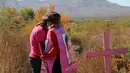 Dua wanita berpelukan di depan makam putrinya jelang Hari Penghapusan Kekerasan Perempuan Internasional di pemakaman Juarez, Negara Bagian Chihuahua, Meksiko, (24/11). Kekerasan terhadap perempuan sudah jadi pandemi di Meksiko.(AFP Photo/Herika Martinez)