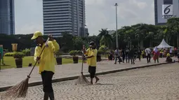 Petugas menyapu membersihkan kawasaan Monas, Jakarta, Senin (1/1). Sebelumnya, kawasan Monas menjadi titik berkumpul warga saat perayaan malam pergantian tahun dan menyisahkan sampah dari pengunjung monas. (Liputan6.com/Faizal Fanani)