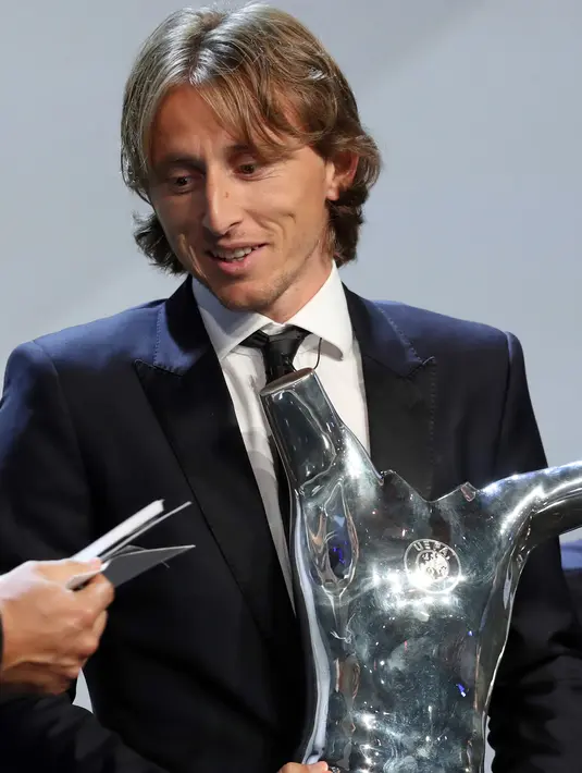 Gelandang Real Madrid asal Kroasia, Luka Modric saat menerima piala pemain terbaik UEFA di The Grimaldi Forum di Monaco, (30/8). Modric berhak atas gelar Pemain Terbaik UEFA dengan mengoleksi 313 poin. (AFP Photo/Valery Hache)