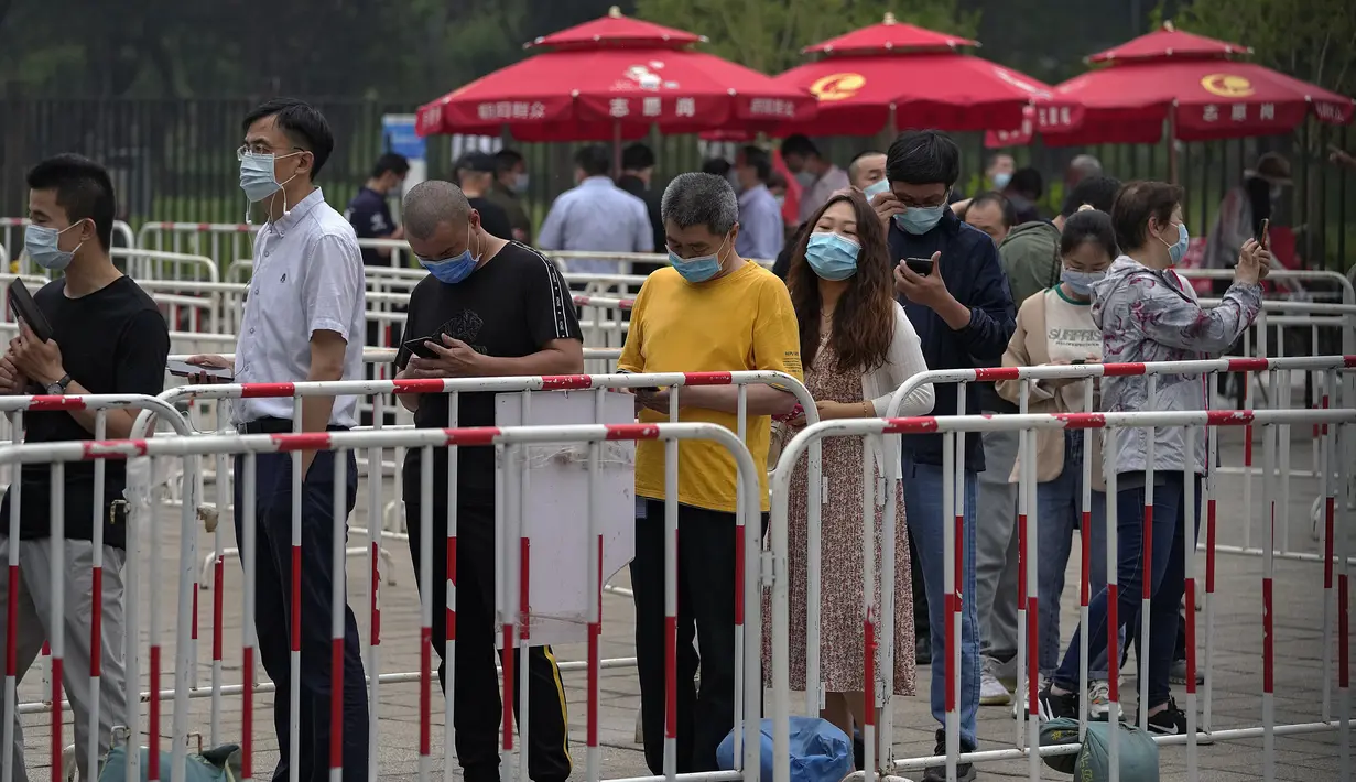 Warga mengenakan masker untuk membantu memutus rantai penyebaran virus corona saat antre menerima vaksin Sinopharm COVID-19 di Central Business District di Beijing, Rabu (2/6/2021). Sinopharm menjadi vaksin pertama dari negara non-Barat yang mendapatkan persetujuan dari WHO. (AP Photo/Andy Wong)