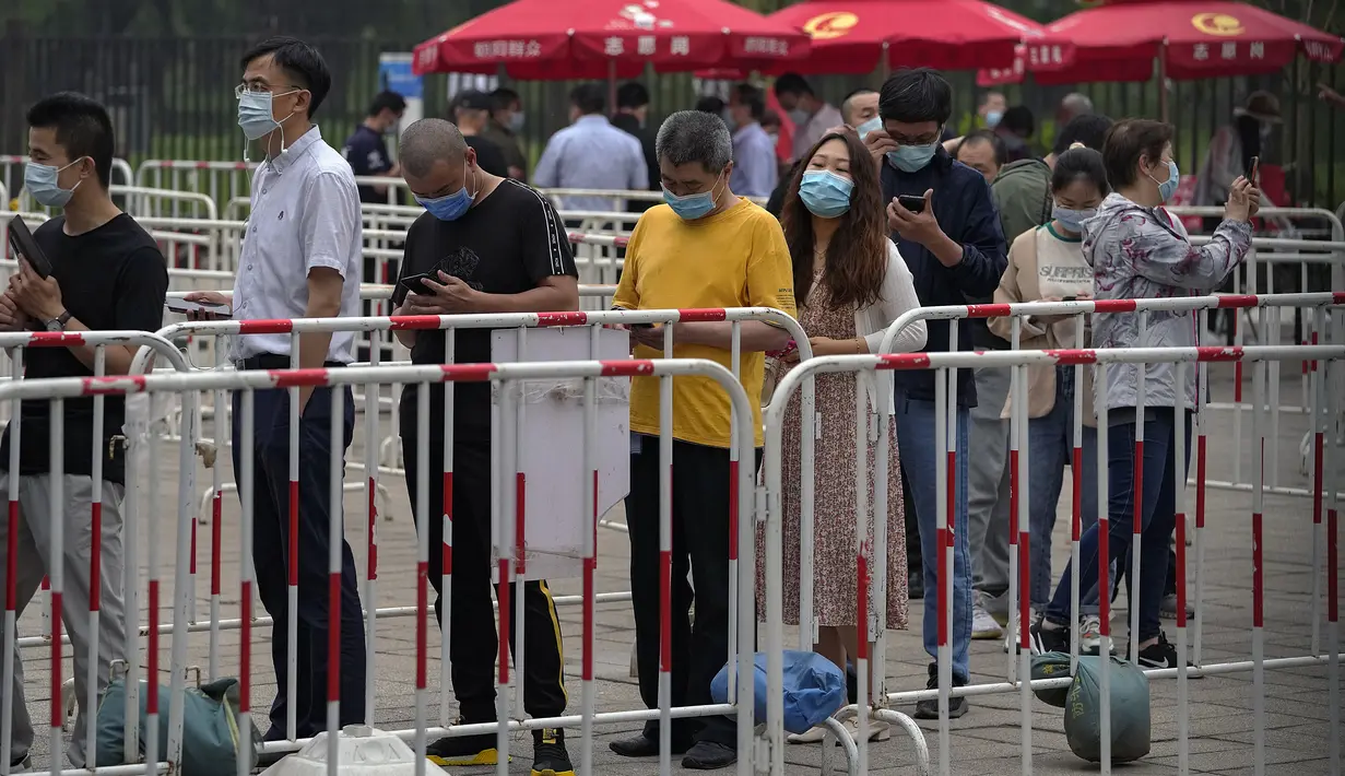 Warga mengenakan masker untuk membantu memutus rantai penyebaran virus corona saat antre menerima vaksin Sinopharm COVID-19 di Central Business District di Beijing, Rabu (2/6/2021). Sinopharm menjadi vaksin pertama dari negara non-Barat yang mendapatkan persetujuan dari WHO. (AP Photo/Andy Wong)